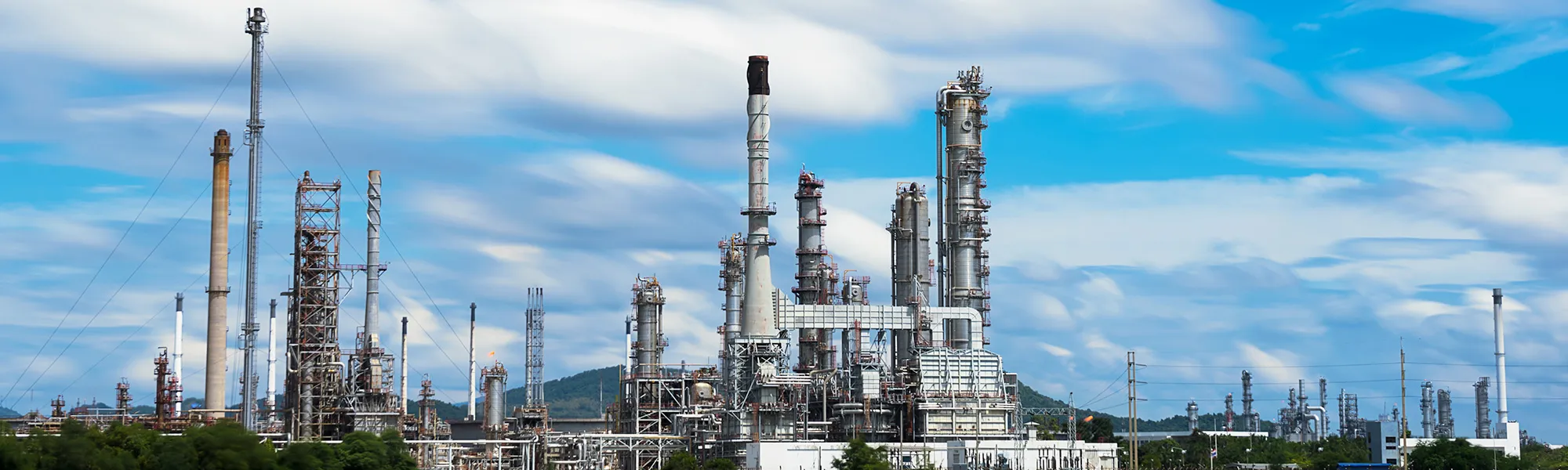 Industrial process plant with stacks and columns under a blue sky